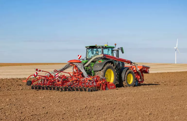 Barre de semis BTFR 5030 et trémie fontale TF attelées à un tracteur John Deete au travail