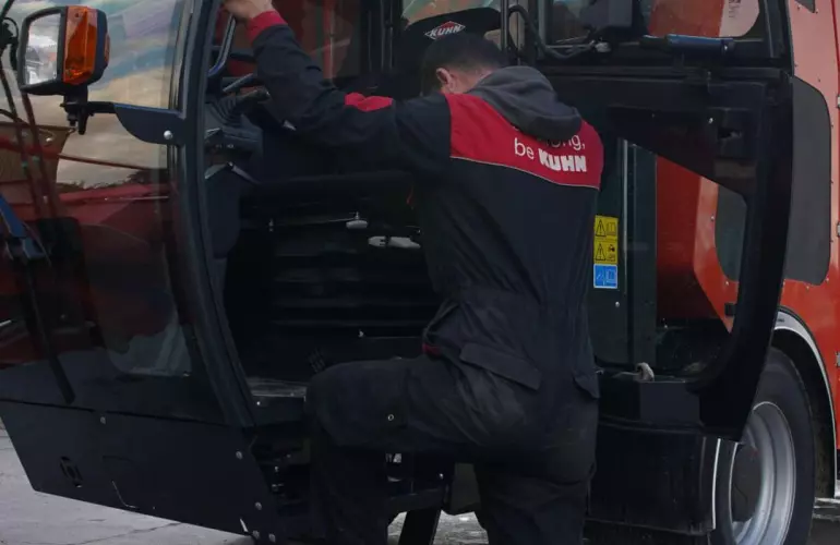 Vue sur la montée en cabine d'une mélangeuse automotrice SPV KUHN