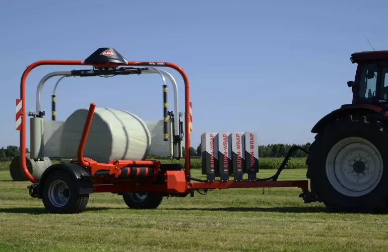 Enrubanneuse pour balles rondes RW 1800 enrubannant des balles dans un champ.