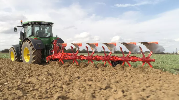 Charrue VARI-MASTER L au travail avec un tracteur John Deere