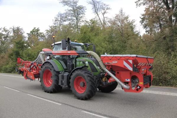 Ensemble tracteur-machines équipé d'une trémie frontale TF 1512 avec répartition des charges au transport