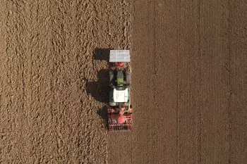 Photo aérienne de la trémie frontale TF 1512 au travail avec une barre de semis BTF