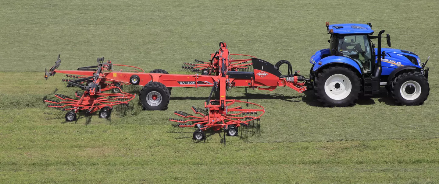 Photo de l'andaineur GA 13031 KUHN au travail dans une prairie