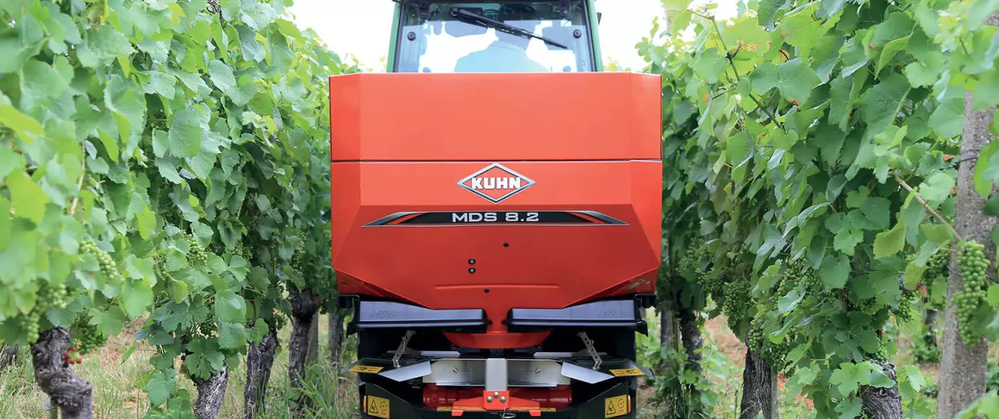 Photo du distributeur d'engrais MDS 8.2 au travail dans un vignoble avec épandage localisé sur deux rangs