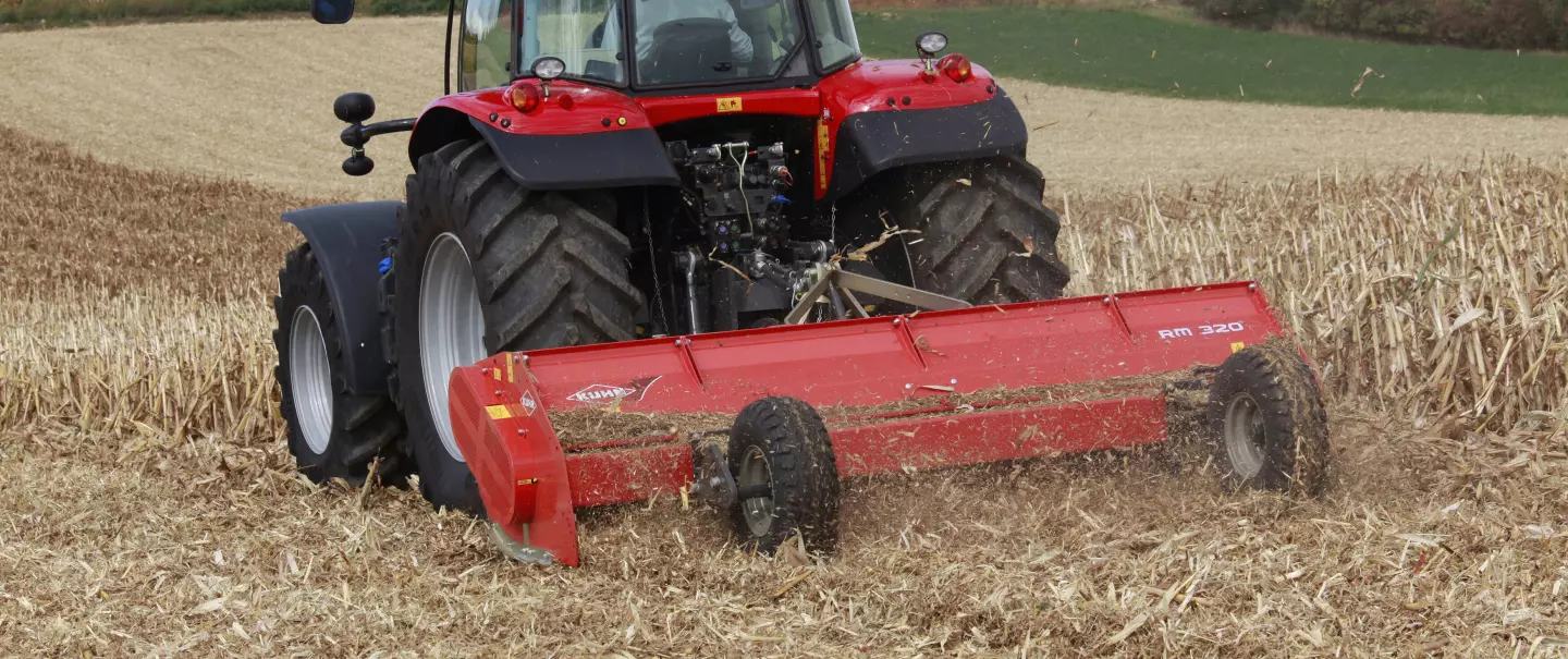 Photo du broyeur RM 320 KUHN au travail dans un champ de maïs