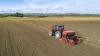 Photo du semoir conventionnel SITERA 3010 à socs au semis dans un paysage avec des champs