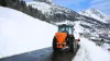 Distributeur VSA de sel, sable en action sur la route en montagne dans la neige